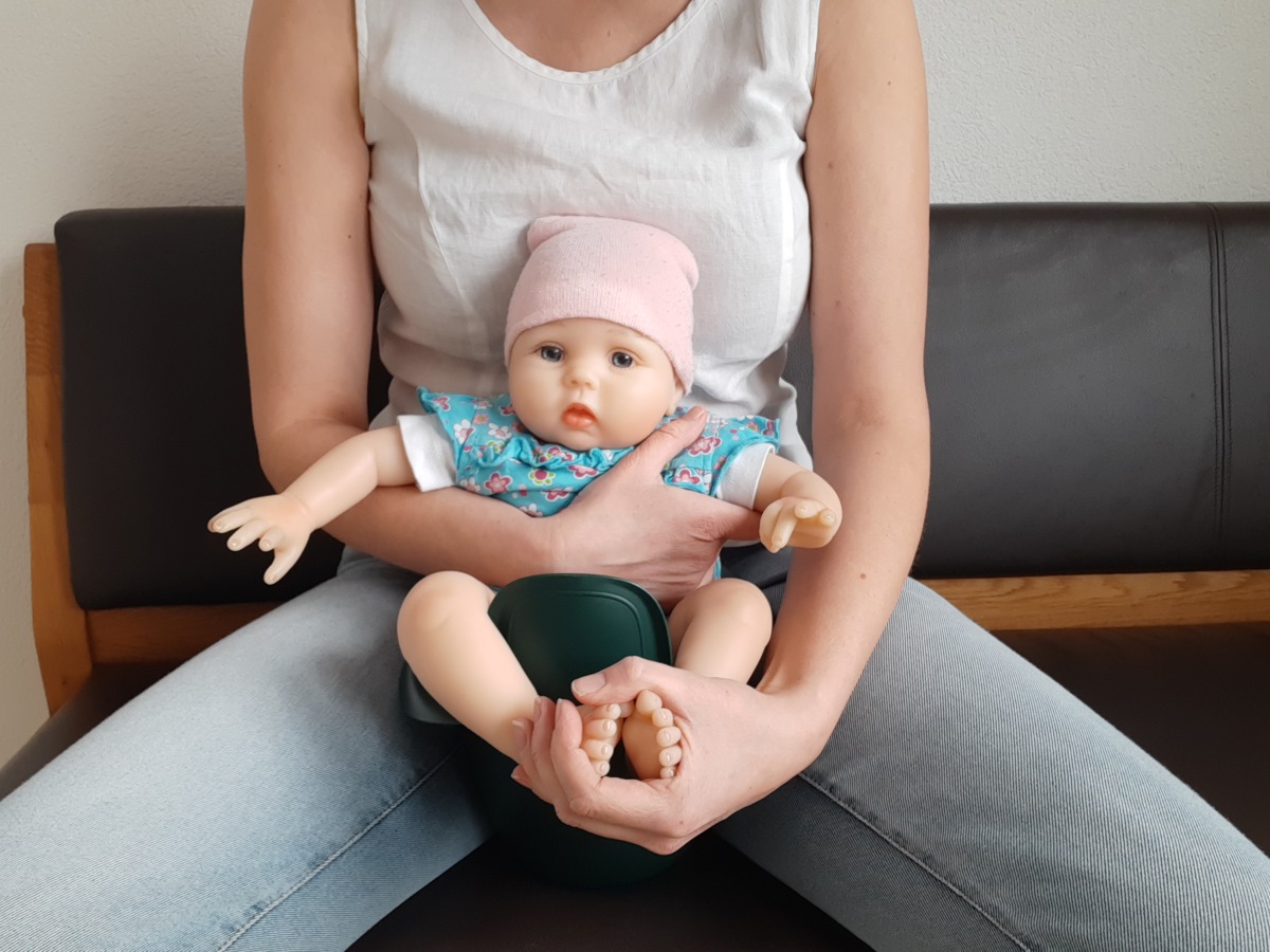 Ältere Babys haben in der Regel eine bessere Kopf- und Rumpfkontrolle, was es ermöglicht, sie in verschiedenen Positionen abzuhalten. Eine beliebte Position ist das Halten des Babys mit dem Rücken zur Brust der abhaltenden Person. Dabei werden die Beine des Babys gespreizt und leicht angehockt, während der Rücken am Bauch lehnt und gut gestützt ist.